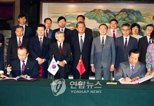 이상옥 외무장관과 첸치천 중국 외교부장이 수교협정문에 서명하고 있다. 1992년 8월 24일. (베이징=연합뉴스)