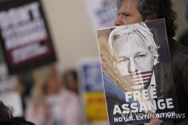 Wikileaks founder Julian Assange supporters hold placards as they gather outside Westminster Magistrates court in London on Wednesday. /AP=Yonhap