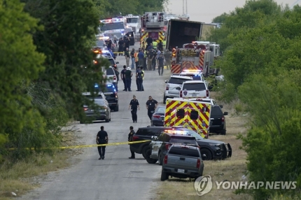 (샌안토니오 AP=연합뉴스) 27일(현지시간) 미국 텍사스주 샌안토니오 남서부 외곽에서 경찰들이 시신이 무더기로 발견된 대형 트레일러 근처에서 일하고 있다.