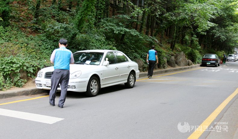 서울 서초구 주정차단속원들이 불법 주정차에 과태료 4만 원을 부과하고 있다. [출처=정수남 기자]