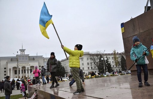 우크라이나 남부 헤르손 메인 광장에서 지난 13일 아이들이 우크라이나 국기를 흔들고 있다. [사진 = 연합뉴스]