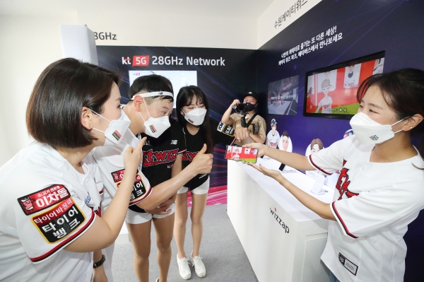KT관계자들과 김주일 응원단장이 KT 위즈파크내 마련된 28GHz 5G체험관에서 메타버스 서비스를 소개하고 있다.