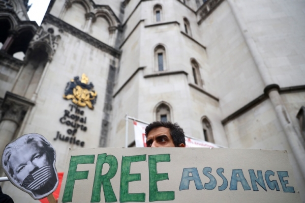 A supporter of WikiLeaks founder Julian Assange protests outside the Royal Courts of Justice in London, UK [Reuters]
